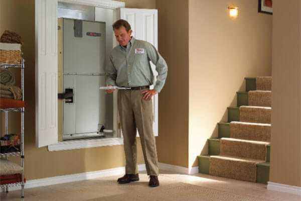 technician with checking clipboard next to an ac