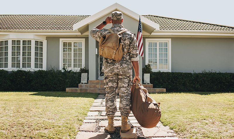 Veteran standing in front of home